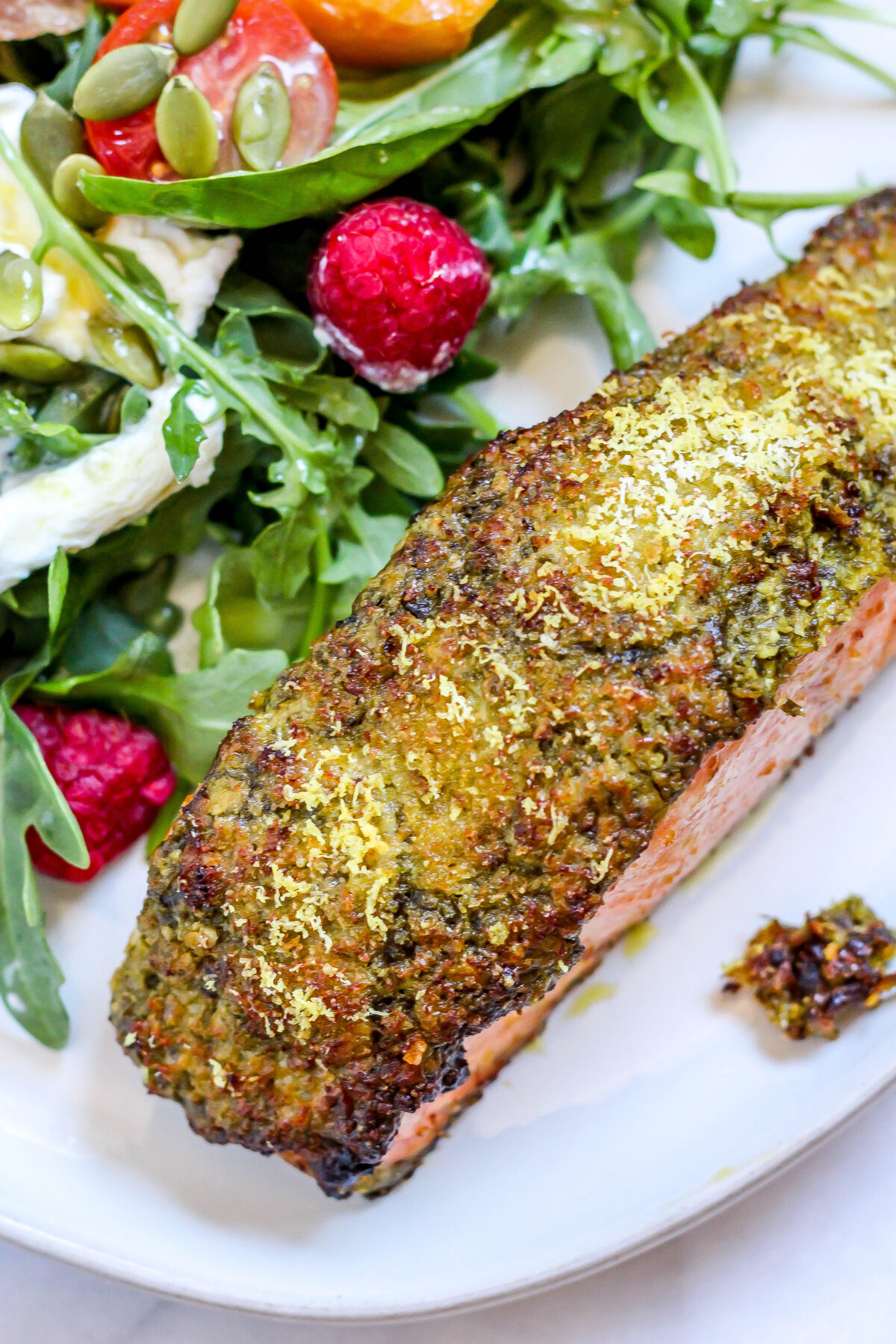 pesto crusted salmon on a plate with salad