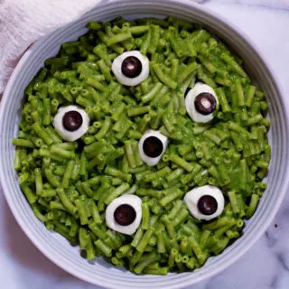 green spooky mac and cheese with mozzarella pearl and black olive 
